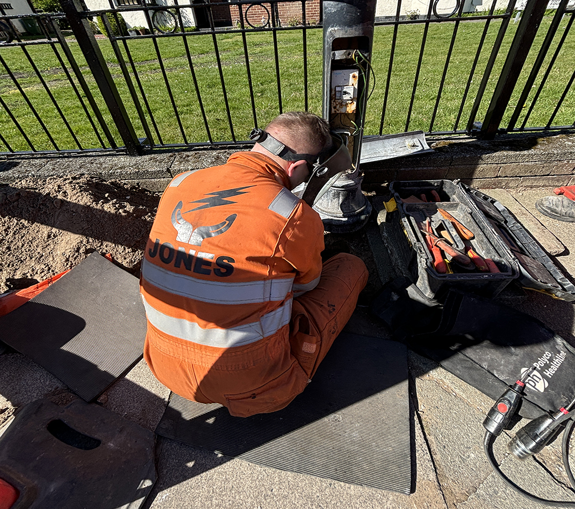 employee fixing a street lamp